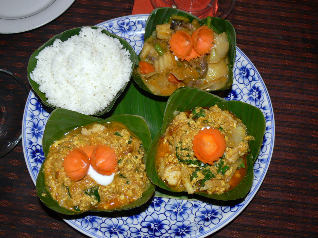 Amok Trey, a traditional Cambodian fish curry, served in banana leaf bowls with steamed rice. A famous dish for travelers seeking authentic Khmer cuisine in Cambodia travel guide listings.