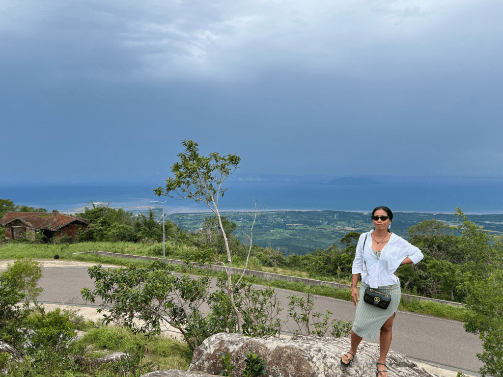 Scenic viewpoint from Bokor Mountain in Cambodia, showing a vast coastal landscape under an overcast sky.