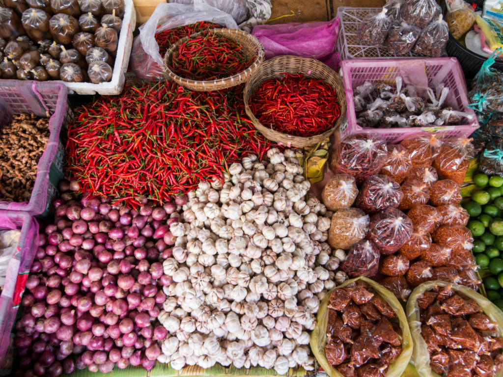 A colorful market in Battambang, Cambodia, featuring red chilies, garlic, onions, and local spices. A top cultural experience for food lovers looking for the best places to visit in Cambodia.