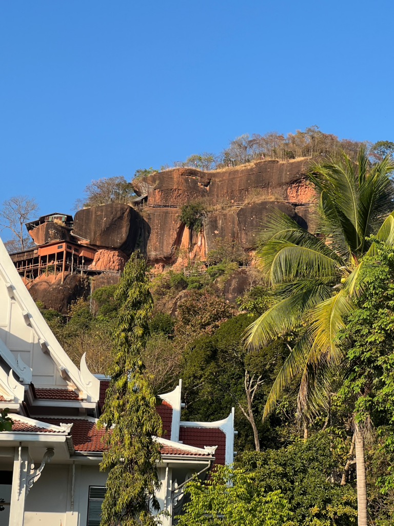 Hidden Thailand: A stunning view of Wat Phu Tok perched on a rocky cliff, Unusual places in Thailand: The dramatic landscape of Wat Phu Tok with a traditional Thai temple in the foreground, Hidden gems in Thailand: The breathtaking cliffside temple of Wat Phu Tok, Best secret spots in Thailand: A remote and spiritual mountain retreat at Wat Phu Tok, Off-the-beaten-path Thailand: A unique temple built on towering rock formations in Bueng Kan