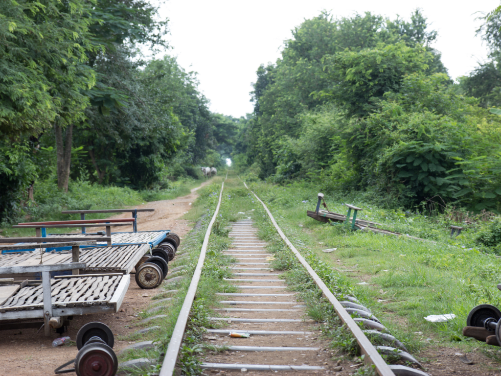 The famous Bamboo Train in Battambang, Cambodia, running on old railway tracks through lush scenery. A fun and historic attraction often included in a Cambodia itinerary.